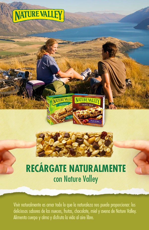 Nature Valley ad with hikers, lake landscape, granola products, bar, and Spanish text.